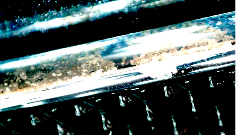 Фото 28. Общий вид типичных коррозионных повреждений на хромированных вставках решетки радиатора в поле зрения портативного цифрового микроскопа.