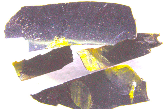 Фото 4. Наслоения вещества желтого цвета на верхней поверхности лакового слоя ЛКП левой части металлического усилителя заднего бампера автомобиля «БМВ» (увеличение 20х).