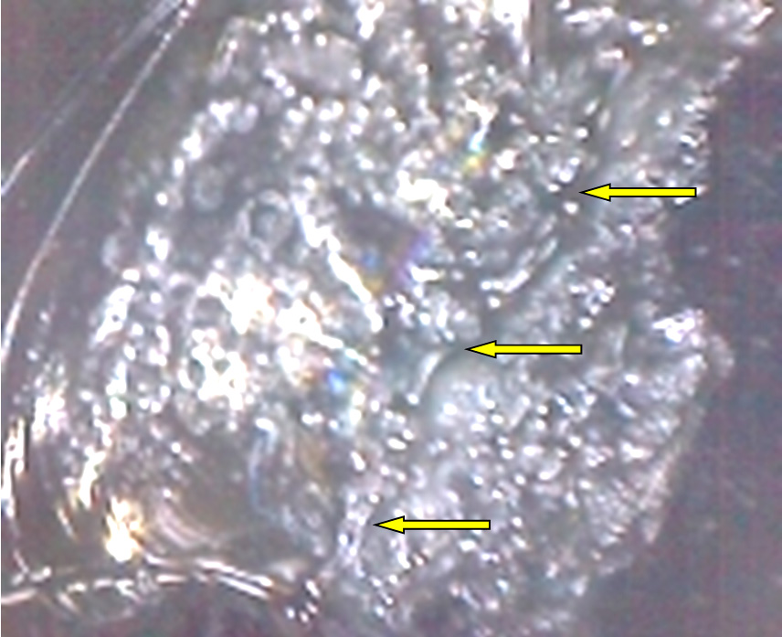 Фото 22. Трещина проходит внутри скола (показано жёлтыми стрелками). Вид через микроскоп (увеличение в 30 раз).