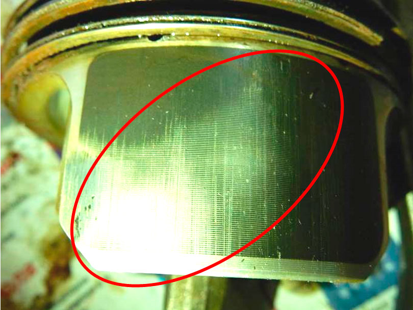 Фото 9. На юбке поршня 1-го цилиндра имеется  боковой износ с диагональным пятном контакта (показан в красном овале)