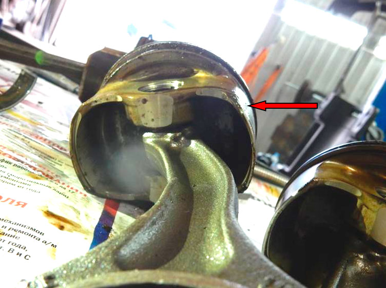 Фото 13. Шатун 1-го цилиндра деформирован в стержне. Сточенный металл на торцевой, нижней части юбки поршня (показан красной стрелкой)